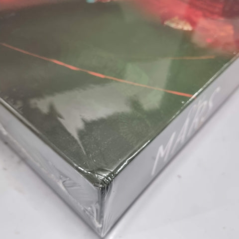 Close-up of a shrink-wrapped On Mars (Damaged) box by Eagle-Gryphon Games. The glossy surface, with abstract red and green patterns, hints at the excitement of unboxing this Mars colony board game. "On Mars" branding is partially visible on the corner.