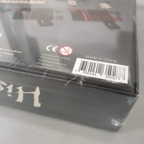 A close-up of a shrink-wrapped Pax Hispanica (Damaged) board game box by Ion Game Design, featuring a barcode, Made in China label, warning symbols for small parts and under-3 age restriction. Hidden roles may be included.