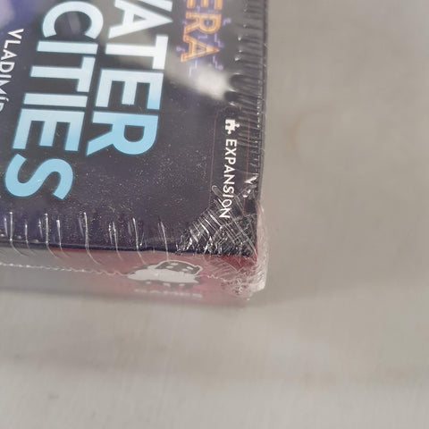 Close-up of a slightly wrinkled corner on the shrink-wrapped Underwater Cities: Data Era Expansion (Delicious Games) box by Delicious Games, showing "EXPANSION" and part of "CITIES" on the side. Condition: Damaged.