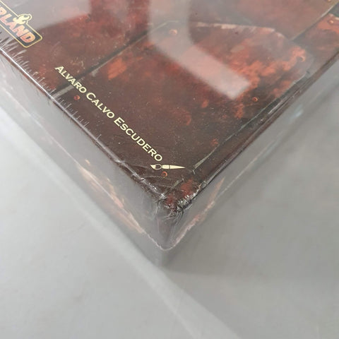 A close-up of a shrink-wrapped Age of Innovation (Damaged) board game by Capstone Games, showing a slightly damaged bottom corner and gold-printed Álvaro Calvo Escudero name with a small scissors icon on the side.