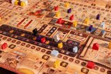A close-up of Garphill Games’ "Ezra and Nehemiah" board game with colorful tokens and wooden pieces—red, yellow, purple, black, and blue—arranged to depict Jerusalem’s temple and Nehemiah’s rebuild across various sections and tracks.