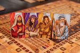 Four illustrated character cards from Garphill Games' "Ezra and Nehemiah" stand upright on a detailed board with tokens and score tracks, depicting men and women in Middle Eastern attire from the era of Cyrus the Great’s decree.