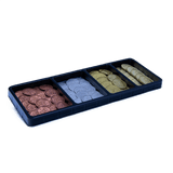 A black tray with four compartments holds stacks of copper, silver, gold, and bronze metal coins from the John Company Second Edition Metal Coins set by Wehrlegig Games—ideal board game accessories on a white background.