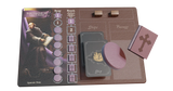 The Pax Hispanica Deluxe Edition by Ion Game Design features a game board displaying a Bartolome de Las Casas card, sway and reach tracks, two wooden cubes, Ship cards, a round wooden token, and a pink book with a cross on its cover.