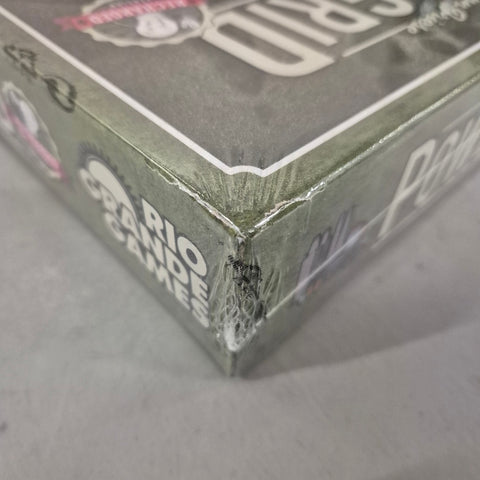 A close-up of a Power Grid Recharged (Damaged) box by Rio Grande Games, with visible crease and tear in the shrink wrap; part of the logo is visible on this economic board game.