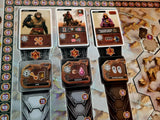 A close-up of Recall by Alion Games shows cards featuring unique tribes, icons, and resources such as gears, crystals, and power symbols. A numbered track from 54 to 72 runs along the board's left edge.