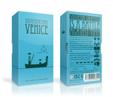 Two blue "Souvenirs from Venice" boxes by Oink Games show black silhouettes of landmarks and gondolas. The back likens souvenir shopping to a board game, with icons for suitcases, souvenirs, and tile collection fun.