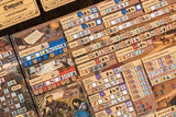 A close-up of The Anarchy by Renegade Game Studios, a medieval strategy game featuring illustrated boards filled with colorful tokens, icons, and cards showing castles, weapons, and characters.