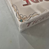 Close-up of the corner of a sealed Ticket to Ride: Europe 15th Anniversary (Damaged) box by Days of Wonder, showing ornate gold and blue artwork and part of "Ticket" on the side. The box is wrapped in plastic.