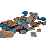 A scattered pile of Stonemaier Games Vantage Metal Coins—blue, gold, copper, and silver board game accessories—each marked with numbers or symbols like 1, 5, 10, and 2x.